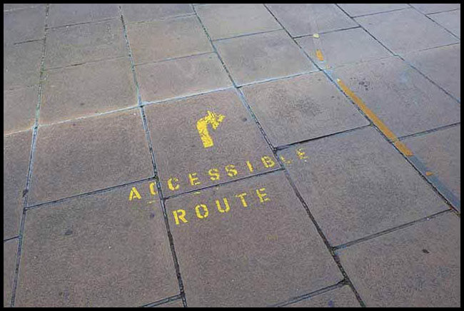 Concrete painted with an arrow and the words Accessible Route